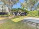 Private grassy backyard with mature trees and concrete patio, perfect for outdoor relaxation and entertaining at 9027 Pebble Creek Dr, Tampa, FL 33647