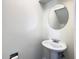 Simple half bathroom with pedestal sink, round mirror, and a clean, neutral palette at 9027 Pebble Creek Dr, Tampa, FL 33647