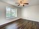 Empty bedroom boasting wood floors, ceiling fan, and a large window at 9027 Pebble Creek Dr, Tampa, FL 33647