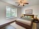 Cozy bedroom with wood floors, ceiling fan, and a plush rug under bed at 9027 Pebble Creek Dr, Tampa, FL 33647