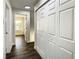 Hallway with dark wood floors, closet, and a view into a room with a window at 9027 Pebble Creek Dr, Tampa, FL 33647