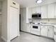 Bright kitchen with white cabinets, stainless steel microwave, and light gray tile floors at 9027 Pebble Creek Dr, Tampa, FL 33647