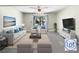 Cozy living room with sofa, chairs, and sliding glass doors to the outdoors at 9027 Pebble Creek Dr, Tampa, FL 33647