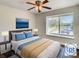 The main bedroom has a bed, window, bedside tables and lamps, and artwork at 9027 Pebble Creek Dr, Tampa, FL 33647