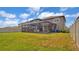 Wide backyard with a screened-in patio and view of neighboring houses at 9456 Channing Hill Dr, Sun City Center, FL 33573