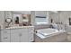 Bathroom featuring soaking tub and white cabinets and countertops at 9456 Channing Hill Dr, Sun City Center, FL 33573