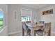 Inviting dining area featuring a glass-top table, comfortable seating, and natural light streaming through the window at 9456 Channing Hill Dr, Sun City Center, FL 33573