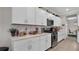 White kitchen boasts stainless steel appliances, modern cabinetry, hexagon backsplash, and plenty of counter space at 9456 Channing Hill Dr, Sun City Center, FL 33573