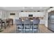 Open kitchen with stainless steel appliances, white cabinets, an island with bar seating and pendant lighting at 9456 Channing Hill Dr, Sun City Center, FL 33573