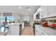Spacious kitchen showcasing white cabinets, quartz countertops, stainless steel appliances, and an adjacent dining area at 9456 Channing Hill Dr, Sun City Center, FL 33573