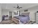 Main bedroom features a tray ceiling, ceiling fan, white nightstands and dressers, and wood floor at 9456 Channing Hill Dr, Sun City Center, FL 33573