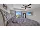 Main bedroom with a tray ceiling, ceiling fan, modern mirror, and blue accents at 9456 Channing Hill Dr, Sun City Center, FL 33573