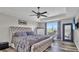Main bedroom features a tray ceiling, ceiling fan, large window, and stylish furniture at 9456 Channing Hill Dr, Sun City Center, FL 33573