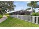 Beautiful backyard view with a white fence, lush landscaping, and screened-in patio area at 12928 Twin Bridges Dr, Riverview, FL 33579