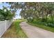 Scenic view of a paved walking path along a white fence with lush landscaping at 12928 Twin Bridges Dr, Riverview, FL 33579