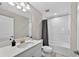 Bright bathroom with a white vanity, neutral walls, and a shower-tub combo with a grey curtain at 12928 Twin Bridges Dr, Riverview, FL 33579