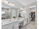 Elegant bathroom with double vanity, walk-in shower, and well-lit mirrors at 12928 Twin Bridges Dr, Riverview, FL 33579