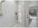 Modern bathroom shower with white subway tile and glass door, plus outdoor access to the pool area at 12928 Twin Bridges Dr, Riverview, FL 33579