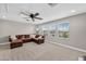 Spacious bonus room with comfortable seating, ceiling fan and natural light from multiple windows at 12928 Twin Bridges Dr, Riverview, FL 33579