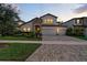 Beautiful two-story home with manicured lawn, stone accents, and three-car garage at 12928 Twin Bridges Dr, Riverview, FL 33579
