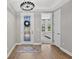Bright foyer featuring hardwood floors, an elegant chandelier, and a view into the bedroom at 12928 Twin Bridges Dr, Riverview, FL 33579