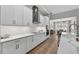 Modern white kitchen with stainless steel appliances and an open floor plan leading to the dining room at 12928 Twin Bridges Dr, Riverview, FL 33579