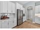 Well-lit kitchen featuring stainless steel refrigerator and white cabinetry at 12928 Twin Bridges Dr, Riverview, FL 33579