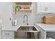 The laundry area features a stainless steel farmhouse sink, white countertops, modern faucet, and open shelving at 12928 Twin Bridges Dr, Riverview, FL 33579