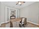 Neutral toned home office with hardwood floors, large desk and glass doors at 12928 Twin Bridges Dr, Riverview, FL 33579
