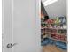 Walk-in pantry with wood-look flooring, filled with metal shelving and a variety of pantry staples at 12928 Twin Bridges Dr, Riverview, FL 33579