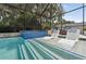 A luxurious screened-in pool with steps leading into the spa, and lounge chairs for relaxing at 12928 Twin Bridges Dr, Riverview, FL 33579