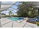Stunning screened-in pool and spa, surrounded by lush landscaping and lounge chairs at 12928 Twin Bridges Dr, Riverview, FL 33579