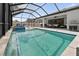 A large screened-in pool with a jacuzzi, lounge area and outdoor kitchen at 12928 Twin Bridges Dr, Riverview, FL 33579