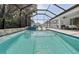 A large screened-in pool with a jacuzzi, lounge area and outdoor kitchen at 12928 Twin Bridges Dr, Riverview, FL 33579