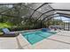 Stunning screened-in pool and spa, surrounded by lush landscaping and lounge chairs at 12928 Twin Bridges Dr, Riverview, FL 33579