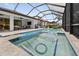 A large screened-in pool with a jacuzzi, lounge area and outdoor kitchen at 12928 Twin Bridges Dr, Riverview, FL 33579