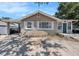 Charming single-story home featuring a covered parking, inviting green door, and lovely front garden at 1432 San Juan Ct, Clearwater, FL 33756