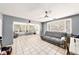 Bright living room boasts tile flooring, ceiling fan, and large windows with blinds, filling the space with light at 1432 San Juan Ct, Clearwater, FL 33756