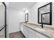 Double sink bathroom with modern fixtures, granite countertops, and sleek, black mirrors at 16313 Scaup Duck Ave, Brooksville, FL 34614