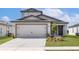Charming home featuring a two-car garage, well-maintained lawn, and an inviting entrance at 16313 Scaup Duck Ave, Brooksville, FL 34614