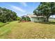 Lush backyard with screened enclosure, mature trees, and a charming exterior view of the home at 1725 Bondurant Way, Brandon, FL 33511