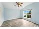 Well-lit bedroom featuring a vaulted ceiling, ceiling fan, and a window with views of lush greenery at 1725 Bondurant Way, Brandon, FL 33511