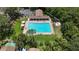 Aerial view of the community pool featuring a spacious pool, clubhouse, lounge chairs, and shade structures at 1725 Bondurant Way, Brandon, FL 33511