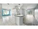 Open kitchen featuring an island with sink, white cabinets and tile floors at 1725 Bondurant Way, Brandon, FL 33511