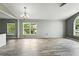 Bright living room features modern light fixture and plenty of natural light from large windows at 1725 Bondurant Way, Brandon, FL 33511