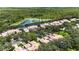 Aerial view of home surrounded by tree cover and near a lake at 17544 Fairmeadow Dr, Tampa, FL 33647