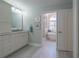 Bathroom featuring white cabinets and a glimpse of a standalone tub through an open doorway at 17544 Fairmeadow Dr, Tampa, FL 33647