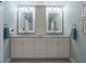 Bright bathroom with dual sinks, marble countertop, white cabinets, and modern fixtures at 17544 Fairmeadow Dr, Tampa, FL 33647