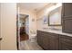 Well-lit bathroom featuring a granite vanity, cabinetry, and convenient access to the bedroom area at 17544 Fairmeadow Dr, Tampa, FL 33647