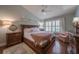 Cozy bedroom featuring a vaulted ceiling, plantation shutters, and warm, inviting decor at 17544 Fairmeadow Dr, Tampa, FL 33647
